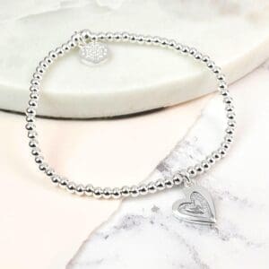 A silver plated bracelet with a stamped heart charm, perfect for stacking.