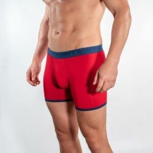 A man sporting Men's Bamboo Boxer shorts in a striking red hue.