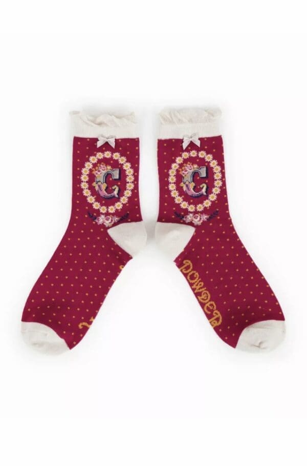 A pair of red and white socks with the letter g on them. (Import placeholder for 7026)