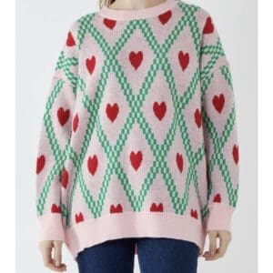 A woman wearing a pink sweater with hearts on it.