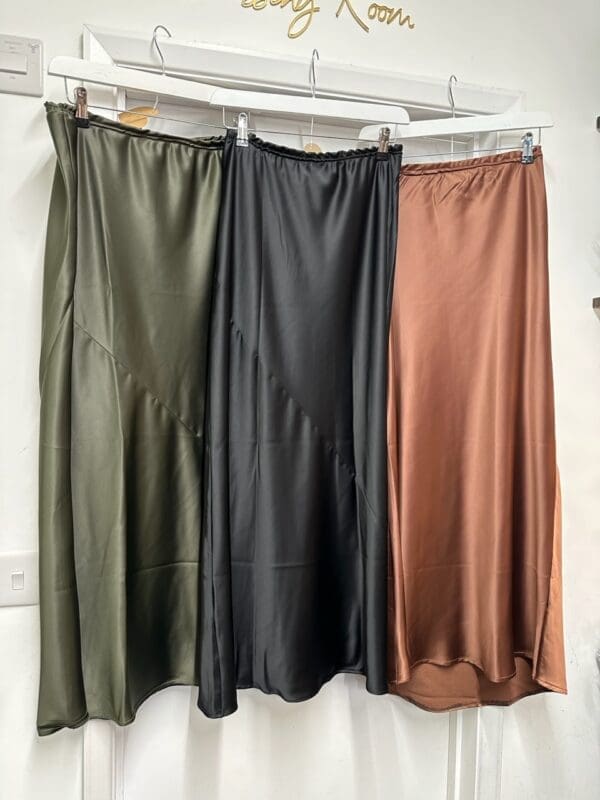 Three skirts hanging on a hanger.