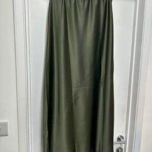A green skirt hanging on a door.