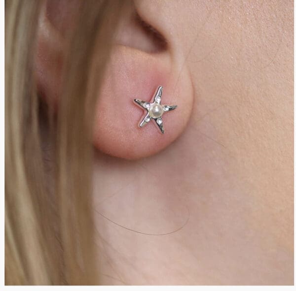 A woman's ear with a star stud earring.