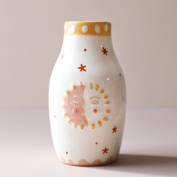 A white vase with a moon and stars on it.