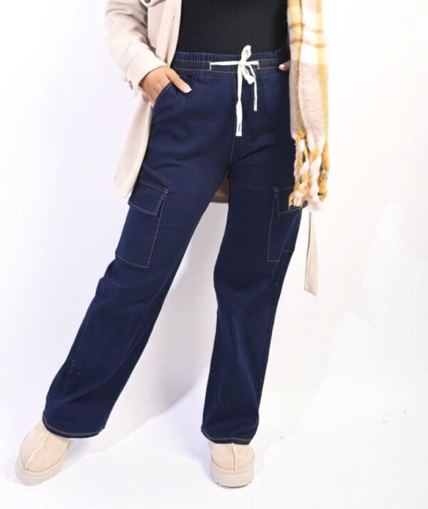 A woman in navy denim cargo pants posing for a photo.