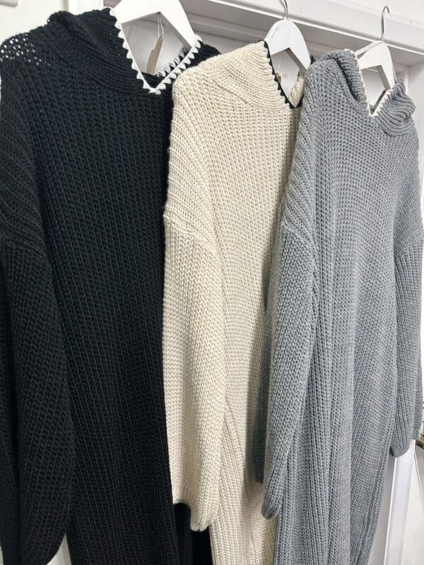 Three sweaters hanging on a hanger.