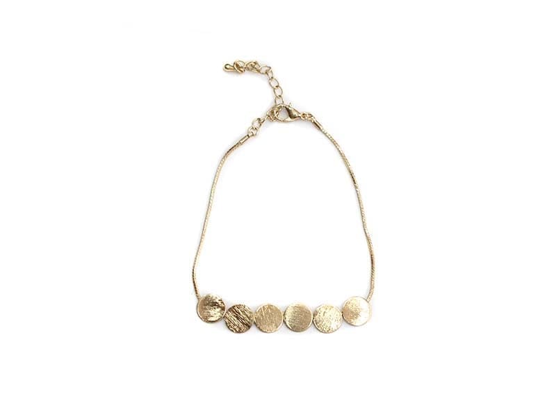A gold - plated bracelet with four circles on it.